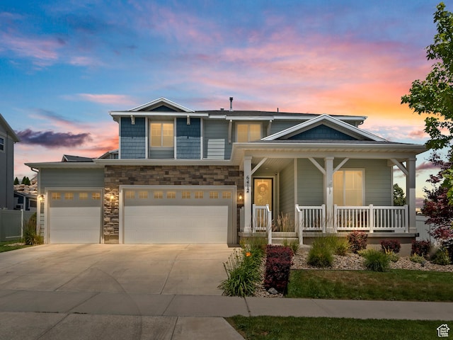 6412 W Chan Reese Dr, West Jordan, UT 84081 - view of front of house with concrete driveway, a porch, stone siding, and an attached garage