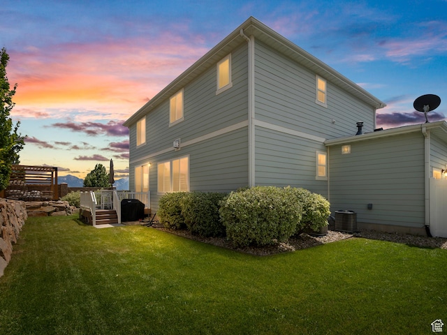 6412 W Chan Reese Dr, West Jordan, UT 84081 - back of property at dusk featuring a lawn and a wooden deck