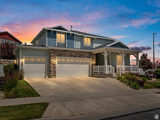 6412 W Chan Reese Dr, West Jordan, UT 84081 - view of front of house featuring covered porch, driveway, an attached garage, and stone siding
