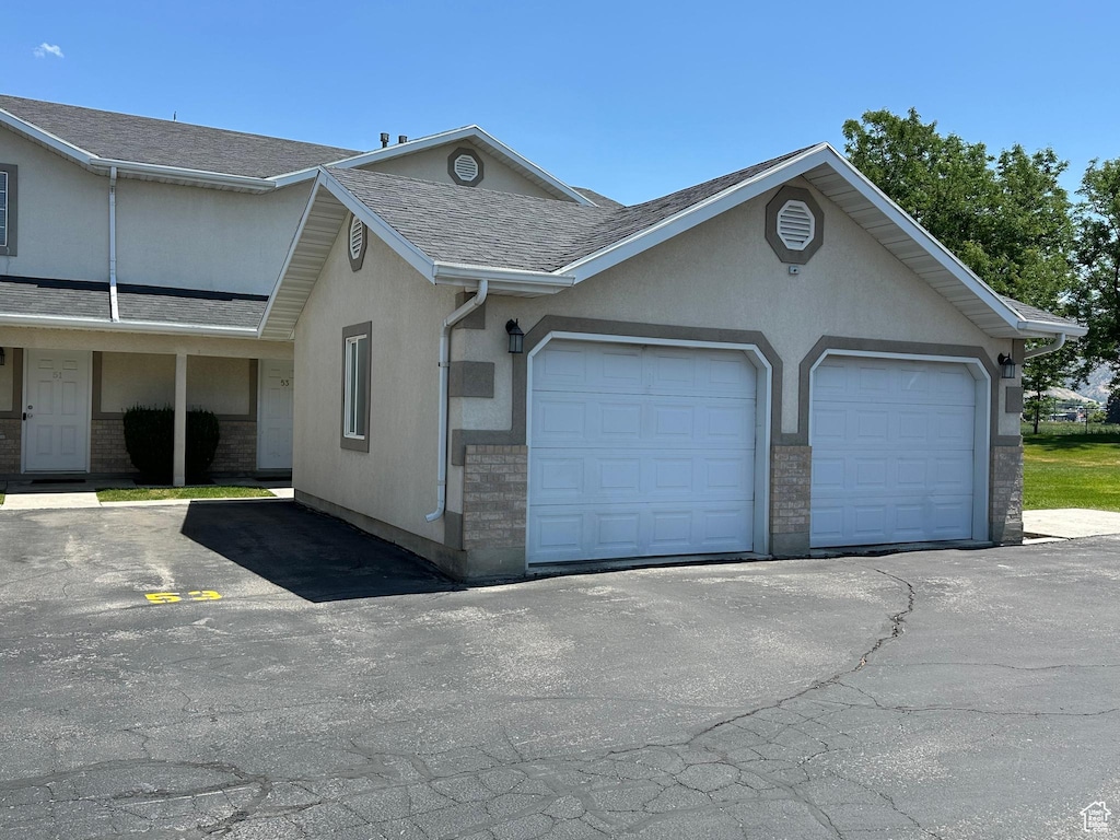 53 W 1315 S, Logan, UT 84321 - view of front of home with a shingled roof, an attached garage, and stucco siding