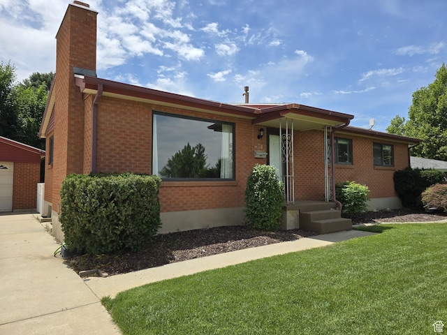 638 E 1050 N, Bountiful, UT 84010 - ranch-style house featuring a chimney, a front lawn, brick siding, a garage, and an outbuilding