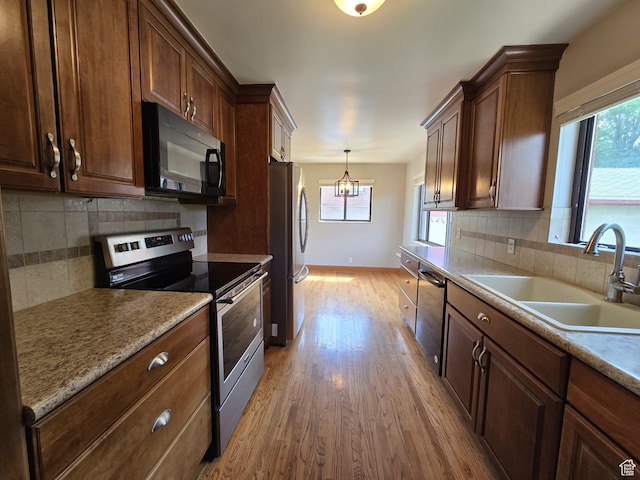 638 E 1050 N, Bountiful, UT 84010 - kitchen with appliances with stainless steel finishes, light wood-style flooring, decorative backsplash, and pendant lighting