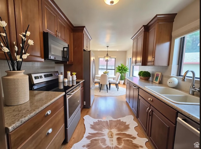 638 E 1050 N, Bountiful, UT 84010 - kitchen with appliances with stainless steel finishes, light wood-style floors, backsplash, and a chandelier