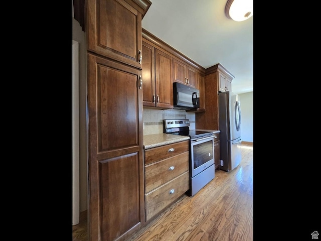 638 E 1050 N, Bountiful, UT 84010 - kitchen featuring appliances with stainless steel finishes, light wood-style flooring, tasteful backsplash, and light countertops
