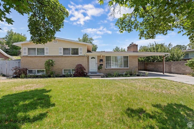 2268 E 7160 S, Cottonwood Heights, UT 84121 - tri-level home with a chimney, a carport, brick siding, and concrete driveway