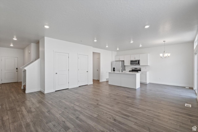 312 N 440 W, Pleasant Grove, UT 84062 - unfurnished living room with a chandelier, recessed lighting, dark wood-type flooring, stairs, and a textured ceiling