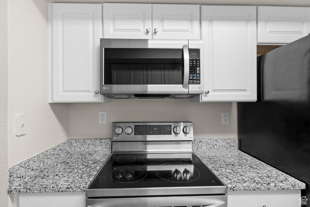 650 S Main St Unit 7105, Bountiful, UT 84010 - kitchen featuring appliances with stainless steel finishes, white cabinets, and light stone counters