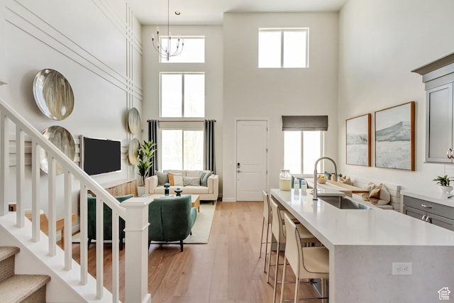 773 W 540 S Unit 344, American Fork, UT 84003 - living area featuring a high ceiling, stairway, light wood-type flooring, and a chandelier