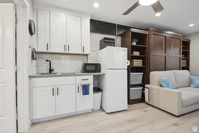 5964 S 610 W, Murray, UT 84123 - kitchen featuring freestanding refrigerator, black microwave, decorative backsplash, a ceiling fan, and white cabinets