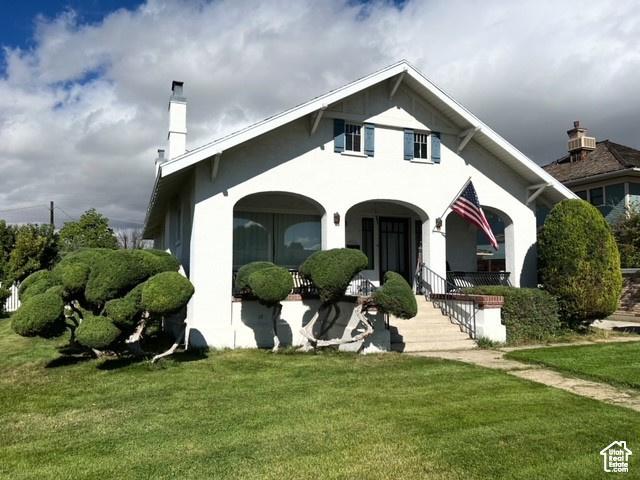 175 N 100 E, Price, UT 84501 - view of front of property with a chimney, a porch, a front lawn, and stucco siding