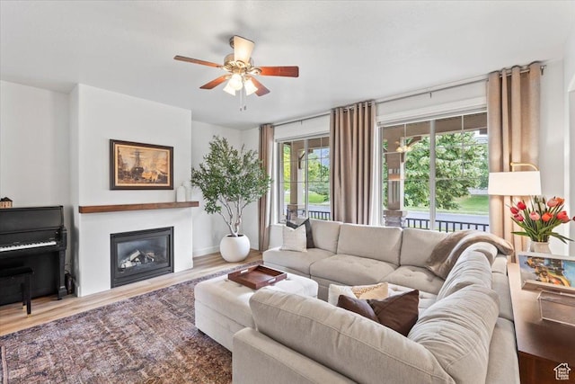 10787 N Town Center Pkwy, Highland, UT 84003 - living area featuring a glass covered fireplace, a ceiling fan, and wood finished floors