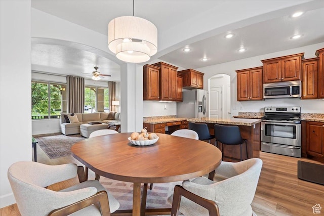 10787 N Town Center Pkwy, Highland, UT 84003 - dining room with light wood-style flooring, arched walkways, recessed lighting, and a ceiling fan