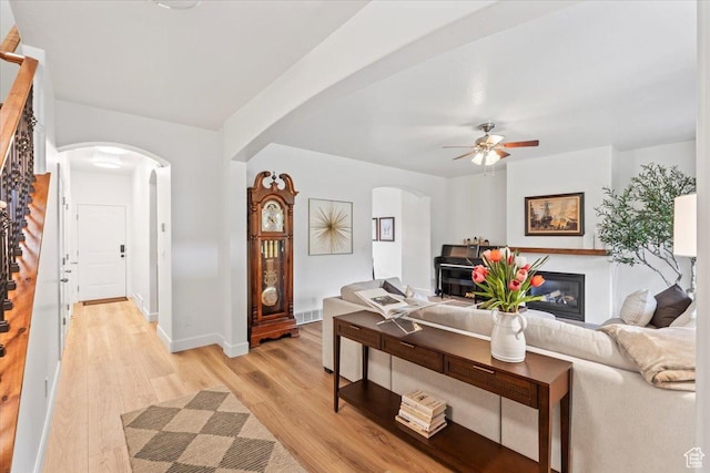 10787 N Town Center Pkwy, Highland, UT 84003 - living room with arched walkways, light wood finished floors, a ceiling fan, and stairs