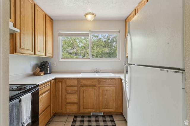 248 E Winslow Ave S Unit 3-C, South Salt Lake, UT 84115 - kitchen featuring freestanding refrigerator, black range with electric stovetop, light tile patterned flooring, under cabinet range hood, and light countertops