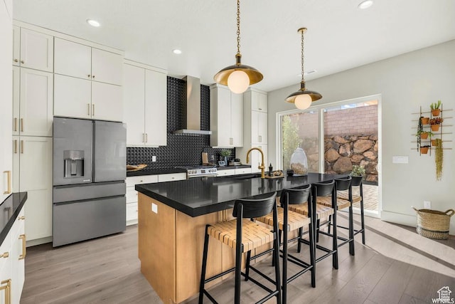 1621 E Centaurus Way Unit 109, Washington, UT 84780 - kitchen featuring appliances with stainless steel finishes, wall chimney exhaust hood, light wood-type flooring, decorative backsplash, and recessed lighting