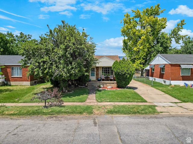 522 E Diana St, South Ogden, UT 84403 - view of property hidden behind natural elements with a front yard, brick siding, a porch, and concrete driveway