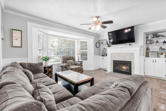 360 S 300 E, Ephraim, UT 84627 - living room featuring a ceiling fan, built in features, crown molding, a textured ceiling, and a fireplace with flush hearth