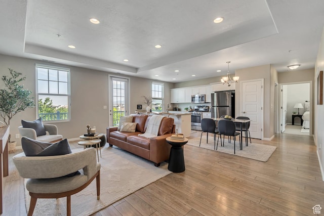 11184 S Waltana Way Unit 205, South Jordan, UT 84095 - living room featuring a raised ceiling, a chandelier, light wood-type flooring, and recessed lighting