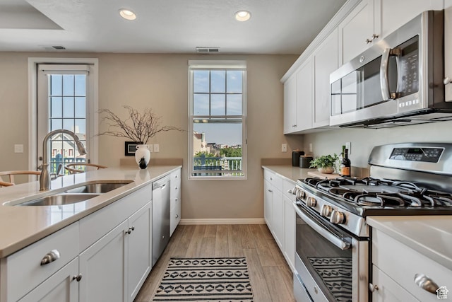 11184 S Waltana Way Unit 205, South Jordan, UT 84095 - kitchen with appliances with stainless steel finishes, light wood finished floors, recessed lighting, plenty of natural light, and light countertops