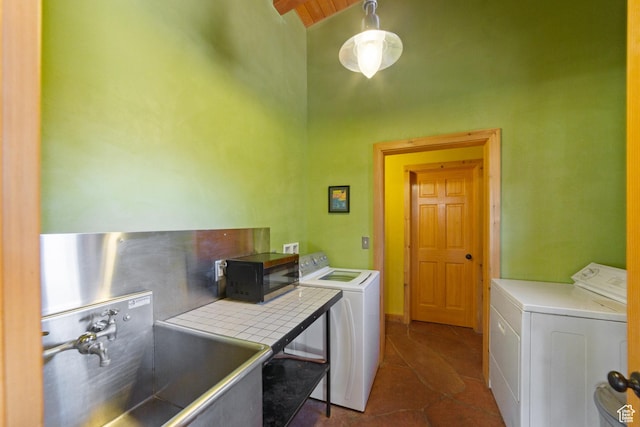 338 Taylor Ln, Castle Valley, UT 84532 - washroom featuring independent washer and dryer, a towering ceiling, and dark tile patterned floors
