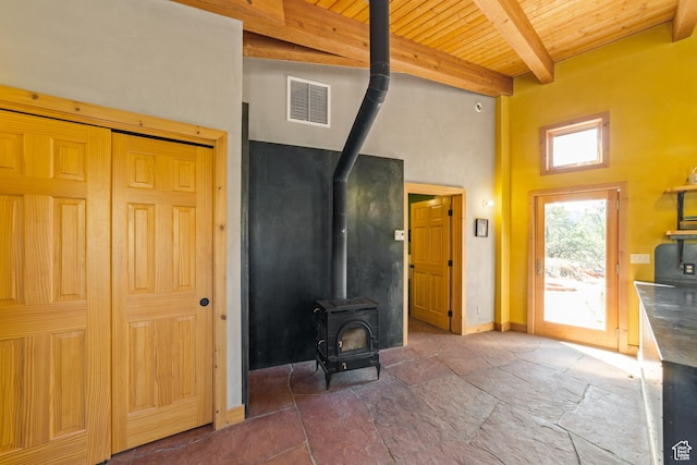 338 Taylor Ln, Castle Valley, UT 84532 - living area with a wood stove, a wood ceiling with exposed beams, a towering ceiling, and dark stone finish flooring