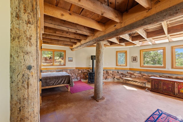 338 Taylor Ln, Castle Valley, UT 84532 - bedroom featuring concrete floors, wainscoting, a wood stove, and beamed ceiling