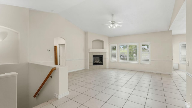 1257 W Bateman Ponds Way S, West Jordan, UT 84084 - unfurnished living room with vaulted ceiling, a ceiling fan, light tile patterned flooring, and a tiled fireplace