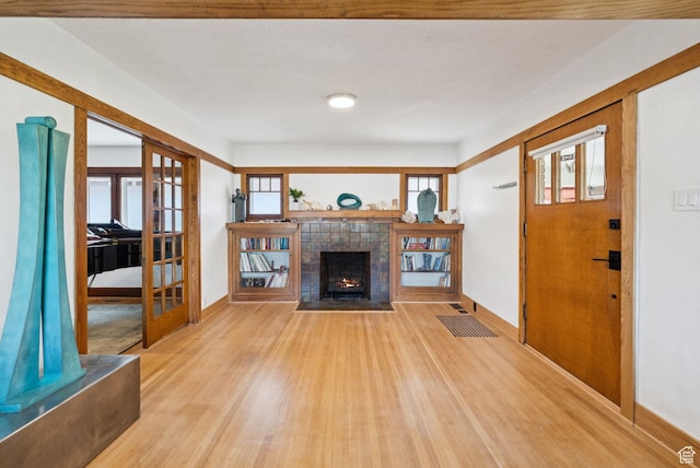 1527 E Emerson Ave S, Salt Lake City, UT 84105 - unfurnished living room featuring light wood finished floors, french doors, and a fireplace