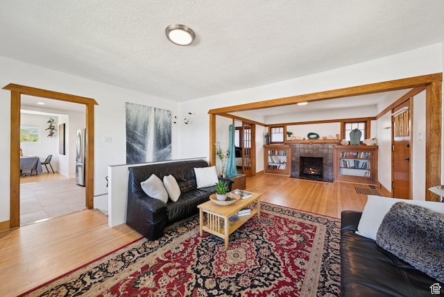 1527 E Emerson Ave S, Salt Lake City, UT 84105 - living area with a tiled fireplace, wood finished floors, and a textured ceiling