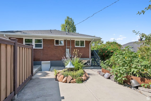 1527 E Emerson Ave S, Salt Lake City, UT 84105 - back of property with stairway, a patio area, and brick siding