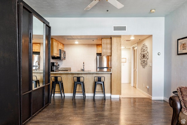 1415 Lowell Ave Unit 160, Park City, UT 84060 - kitchen featuring fridge, black microwave, wood finished floors, a kitchen breakfast bar, and a ceiling fan