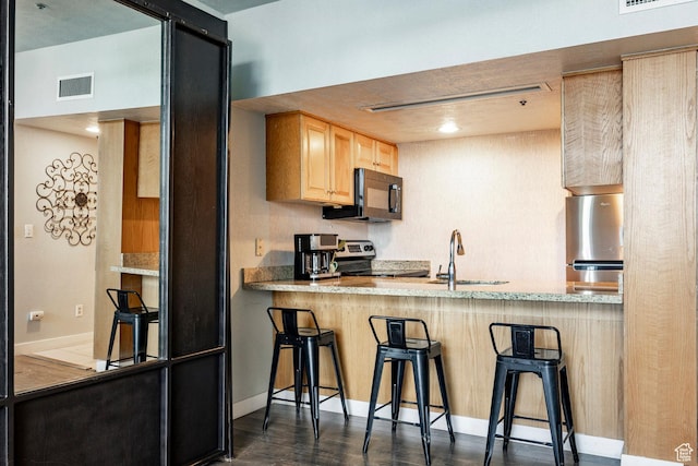 1415 Lowell Ave Unit 160, Park City, UT 84060 - kitchen with appliances with stainless steel finishes, light brown cabinetry, a kitchen breakfast bar, and a peninsula