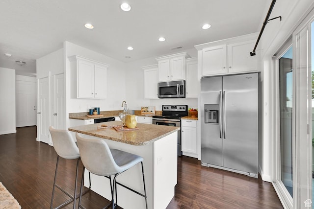 258 W 710 N, Centerville, UT 84014 - kitchen featuring stainless steel appliances, a center island, dark wood-type flooring, white cabinets, and a breakfast bar area