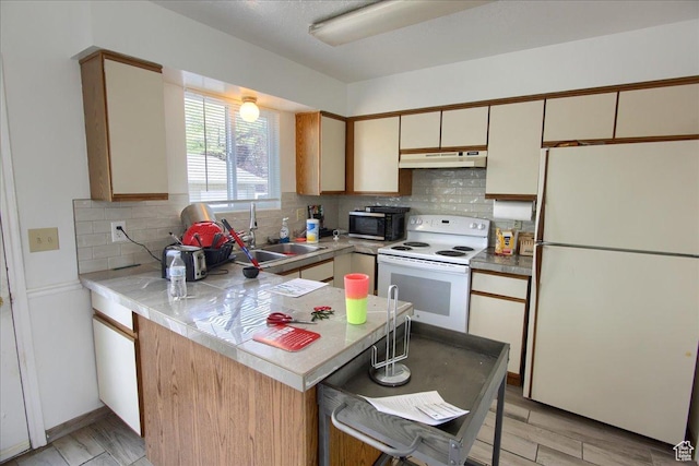 1714 E 5825 S, South Ogden, UT 84403 - kitchen with white appliances, under cabinet range hood, tasteful backsplash, a peninsula, and light countertops