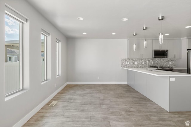 1371 W Stewart Falls Dr, Riverton, UT 84065 - kitchen featuring stainless steel appliances, light countertops, decorative backsplash, recessed lighting, and decorative light fixtures