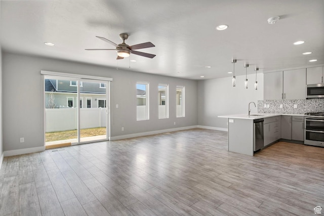 1371 W Stewart Falls Dr, Riverton, UT 84065 - kitchen with appliances with stainless steel finishes, open floor plan, a peninsula, ceiling fan, and light countertops