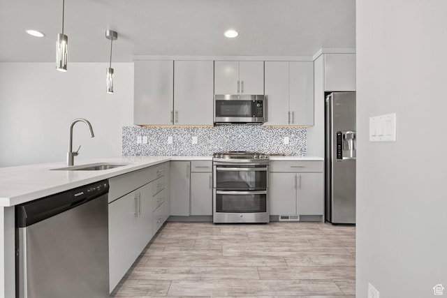 1371 W Stewart Falls Dr, Riverton, UT 84065 - kitchen with stainless steel appliances, a peninsula, light countertops, hanging light fixtures, and recessed lighting