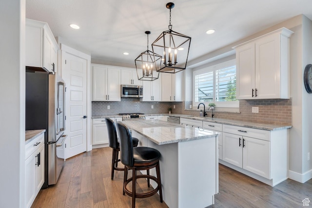 6462 W Shawnee Marie Way, Herriman, UT 84096 - kitchen featuring stainless steel appliances, white cabinets, wood finished floors, a chandelier, and recessed lighting