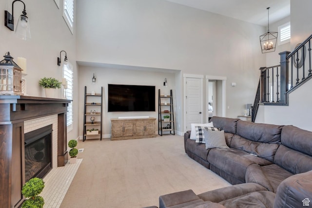6462 W Shawnee Marie Way, Herriman, UT 84096 - living area featuring a towering ceiling, a chandelier, stairway, a glass covered fireplace, and light carpet