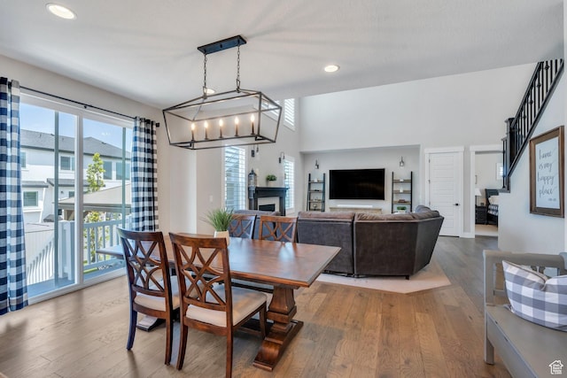 6462 W Shawnee Marie Way, Herriman, UT 84096 - dining space with healthy amount of natural light, wood finished floors, recessed lighting, a fireplace, and a chandelier