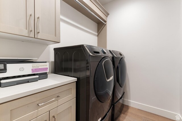 5057 N Foxtail W, Eagle Mountain, UT 84005 - laundry room with washing machine and dryer, light wood-style flooring, and cabinet space