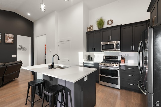 5057 N Foxtail W, Eagle Mountain, UT 84005 - kitchen featuring appliances with stainless steel finishes, high vaulted ceiling, light countertops, a kitchen bar, and wood finished floors