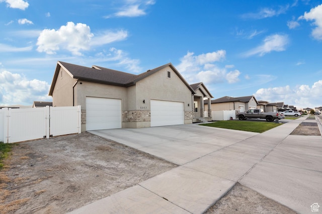 5057 N Foxtail W, Eagle Mountain, UT 84005 - view of side of home featuring a gate, a garage, stucco siding, driveway, and a residential view