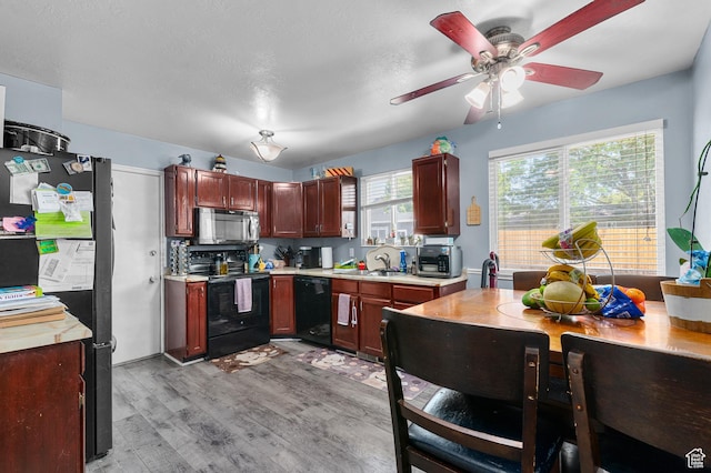 5370 W Cadenza Dr S, West Jordan, UT 84081 - kitchen featuring black appliances, light countertops, light wood-type flooring, and a ceiling fan