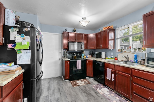 5370 W Cadenza Dr S, West Jordan, UT 84081 - kitchen featuring black appliances, light wood-style floors, light countertops, and dark brown cabinets