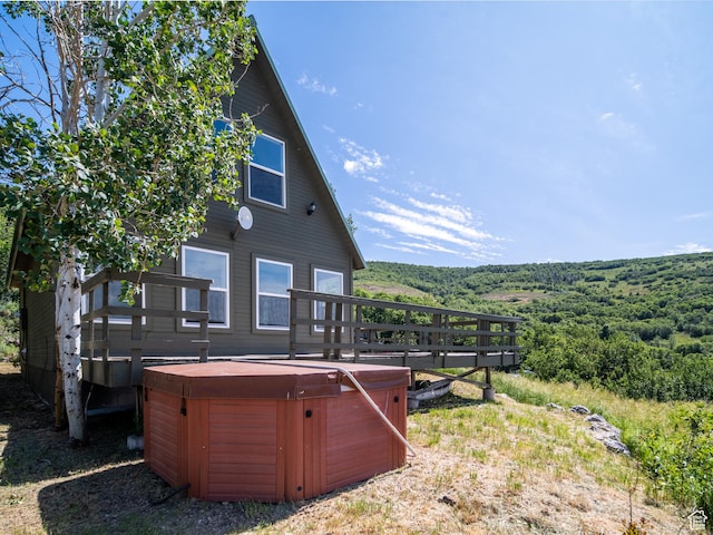 4410 S Upper Aspen Loop Unit 130, Kamas, UT 84036 - rear view of property featuring a hot tub, a wooden deck, and a wooded view