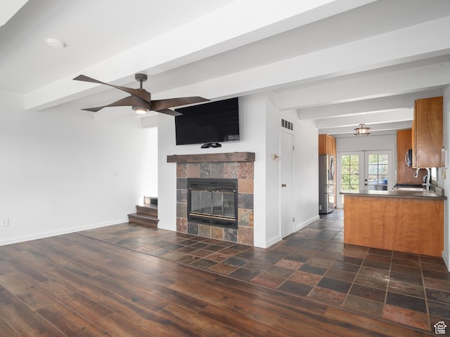 4410 S Upper Aspen Loop Unit 130, Kamas, UT 84036 - unfurnished living room with ceiling fan, beamed ceiling, a tile fireplace, and dark wood finished floors