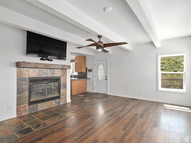4410 S Upper Aspen Loop Unit 130, Kamas, UT 84036 - unfurnished living room with beamed ceiling, a tile fireplace, a ceiling fan, and dark wood-style flooring