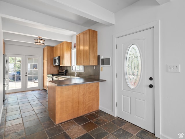 4410 S Upper Aspen Loop Unit 130, Kamas, UT 84036 - kitchen with appliances with stainless steel finishes, stone tile floors, dark countertops, and a peninsula