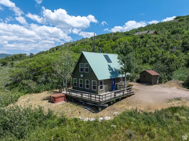 4410 S Upper Aspen Loop Unit 130, Kamas, UT 84036 - rear view of house with a view of trees, a hot tub, a storage shed, and a deck